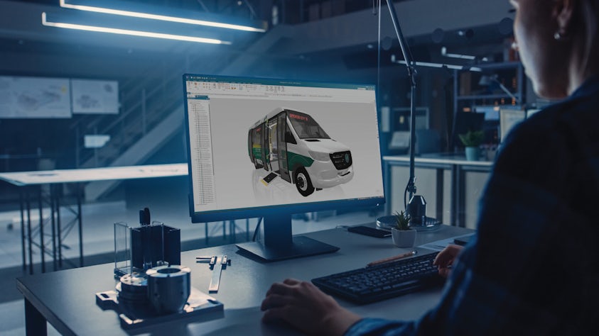 Woman sitting at her desk using Siemens Solid Edge software.