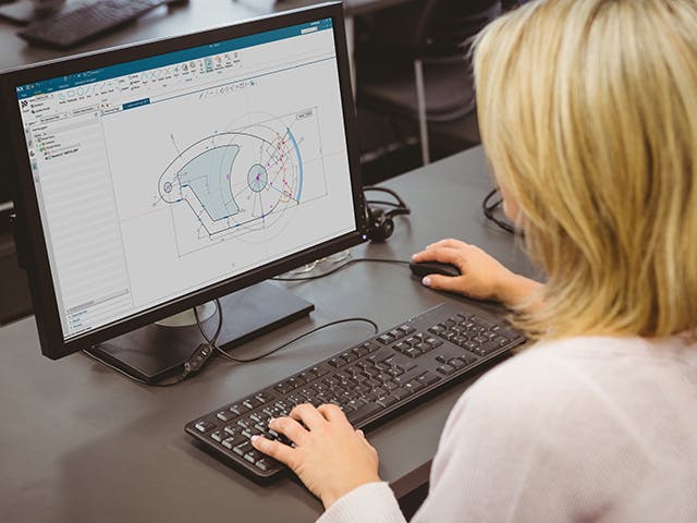 Osoba u počítače používající řešení CAD.